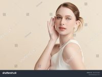 stock-photo-a-beautiful-young-woman-with-clean-fresh-skin-against-a-beige-background-skincare-facial-2633703589