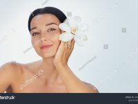 stock-photo-a-serene-young-woman-holds-a-white-flower-by-her-face-symbolizing-purity-and-elegance-her-smooth-2630959461